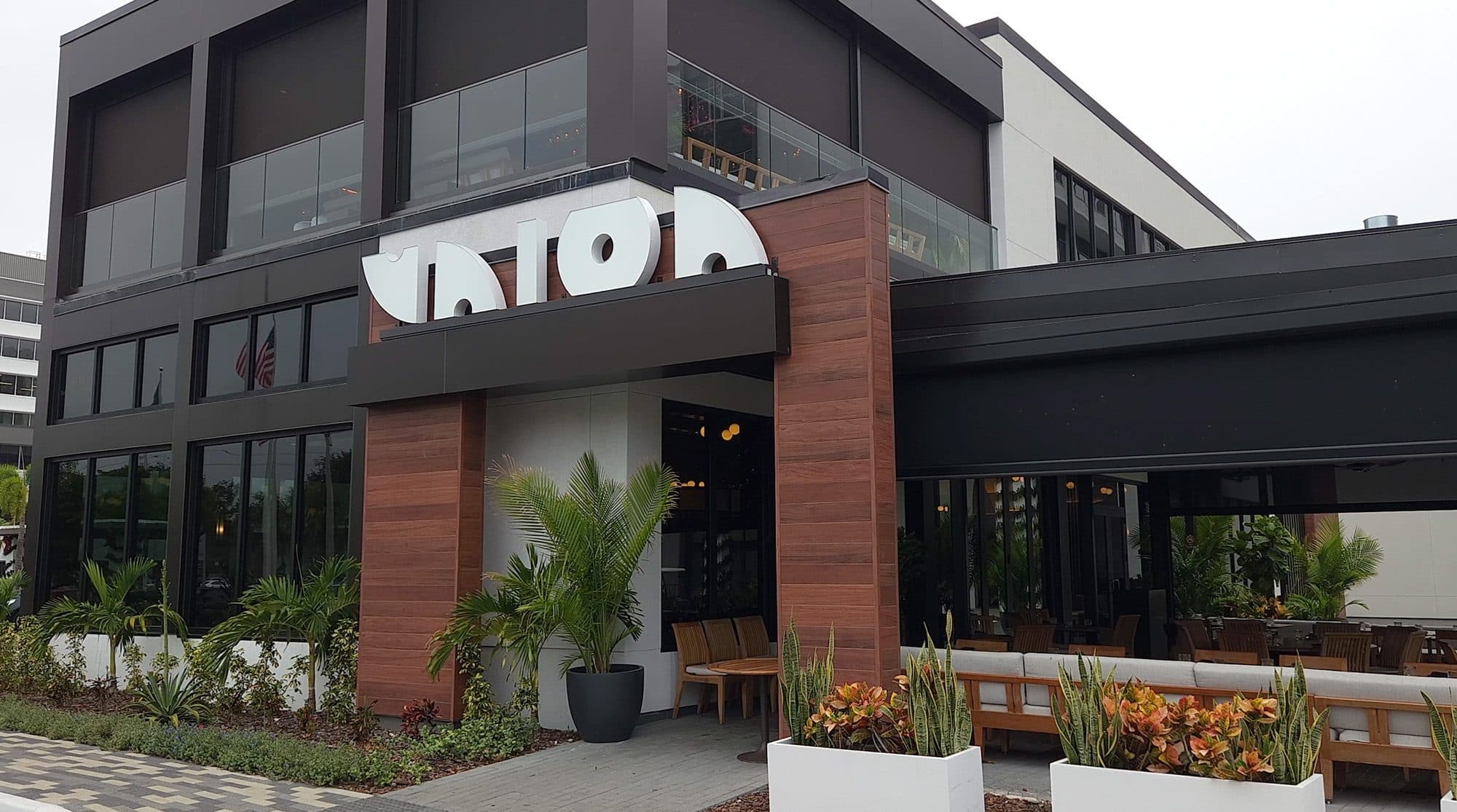 Union New American exterior with wood-clad entry portal and outdoor terrace
