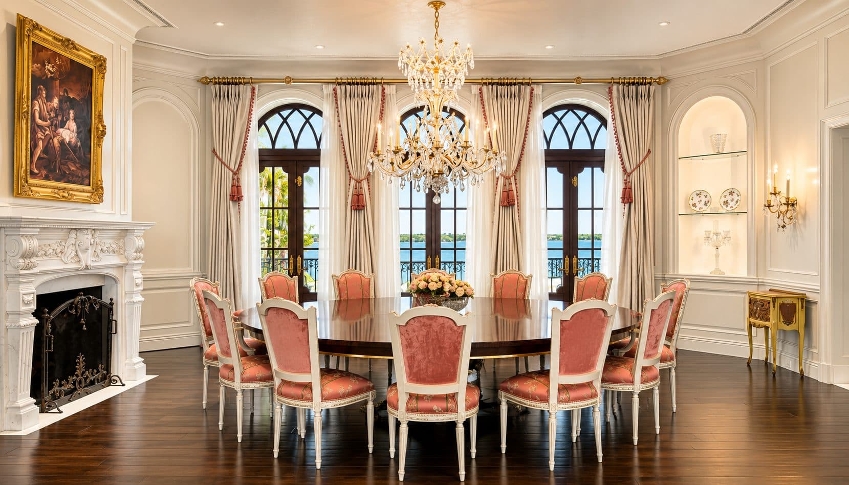 Royal Chateau formal dining room with arched French doors, crystal chandelier, and water views